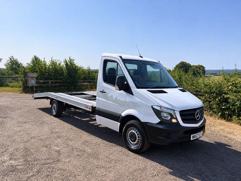 White Mercedes Sprinter car transporter with a loading ramp
